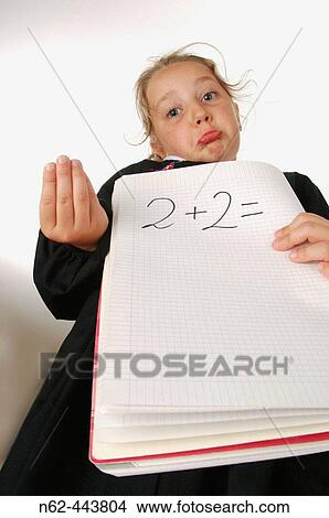 Little girl in elementary schools with displeased expression holds in her hands a exercise book on which it says two plus two equals View Large Photo Image Picture - Little girl in elementary schools with displeased expression holds in her hands a exercise book on which it says two plus two equals. Fotosearch