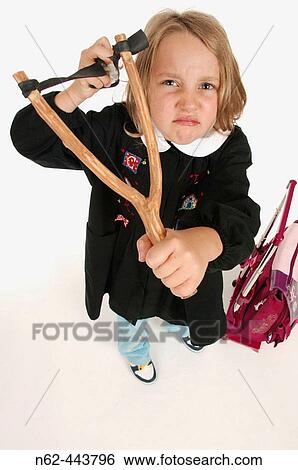 Little girl primary school top view, evilly holds in her hands a slingshot ready to launch a piece of crumpled paper View Large Photo Image Stock Photograph - Little girl primary school top view, evilly holds in her hands a slingshot ready to launch a piece of crumpled paper. Fotosearch