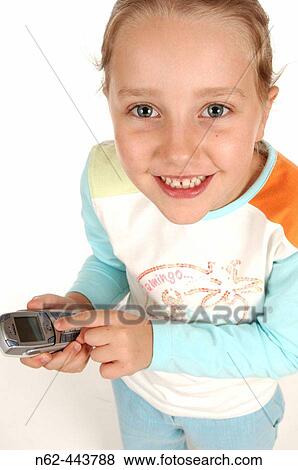 Stock Photo - Little girl smiling top view holds in her hands an old cell phone. Fotosearch