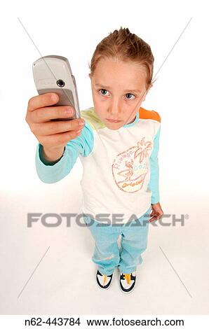 Little girl top view take a photo with her cell phone raising her arm View Large Photo Image Picture - Little girl top view take a photo with her cell phone raising her arm. Fotosearch