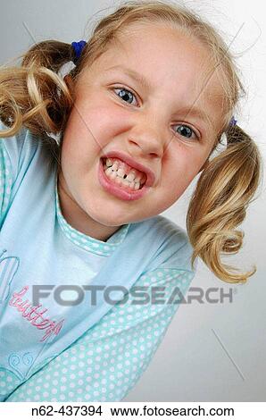 Picture - Little girl with pigtails bottom view makes some funny faces. Fotosearch