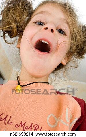 Little girl with pigtails bottom view makes a funny facial expression with the mouth open View Large Photo Image Picture - Little girl with pigtails bottom view makes a funny facial expression with the mouth open. Fotosearch