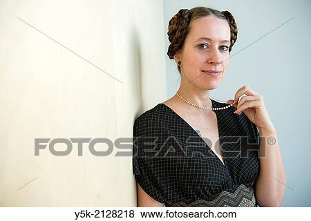 Living room or salon of studio apartment, Eindhoven, Netherlands. Young, attractive woman with tresses and tails in her hear, wearing a pearl neckless inherited from her grandmother. View Large Photo Image Stock Photo - Living room or salon of studio apartment, Eindhoven, Netherlands. Young, attractive woman with tresses and tails in her hear, wearing a pearl neckless inherited from her grandmother.. Fotosearch