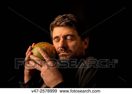 Man embracing the globe with the eye closed, black studio photo sobrefondo View Large Photo Image Stock Photo - Man embracing the globe with the eye closed, black studio photo sobrefondo. Fotosearch