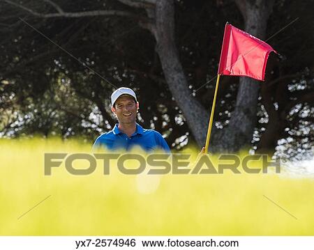 Man holding the flag on the green. View Large Photo Image Stock Photograph - Man holding the flag on the green.. Fotosearch