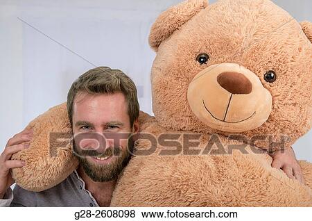 Man playing with big soft toy teddy bear for fun View Large Photo Image Stock Photo - Man playing with big soft toy teddy bear for fun. Fotosearch