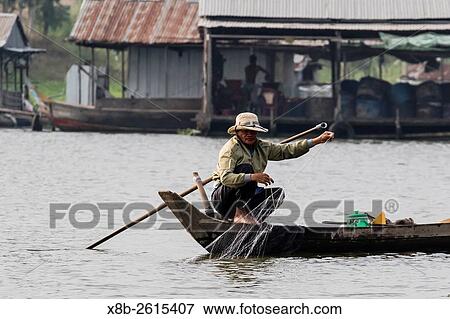 Stock Photo - Man retrieving fishing net in small sampan in Chau Doc, Mekong River Delta, Vietnam.. Fotosearch