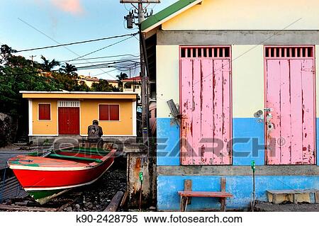Man seen from behind sitting on a boat besides fishermen huts with pink doors in Scottshead, Dominica, Windward Islands, Lesser Antilles, Eastern Caribbean Islands, West Indies, Americas. View Large Photo Image Stock Photography - Man seen from behind sitting on a boat besides fishermen huts with pink doors in Scottshead, Dominica, Windward Islands, Lesser Antilles, Eastern Caribbean Islands, West Indies, Americas.. Fotosearch