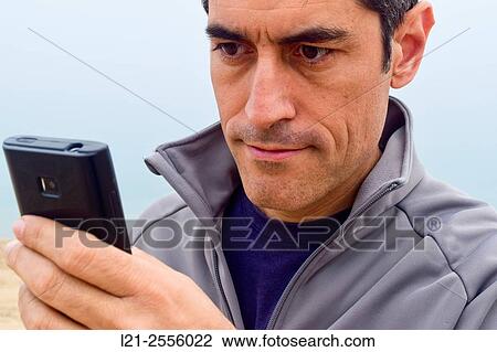 Man using a mobile phone outdoor. Man holding a smartphone. View Large Photo Image Stock Image - Man using a mobile phone outdoor. Man holding a smartphone.. Fotosearch