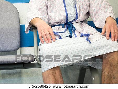 Stock Photography - Man wearing hospital gown waiting to be called by Doctor in day surgery unit in National Health Service hospital in England, United Kingdom.. Fotosearch