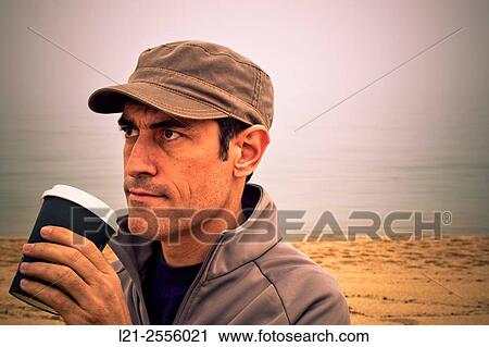 Man with cap is holding a disposable cup of coffee outdoor. View Large Photo Image Stock Image - Man with cap is holding a disposable cup of coffee outdoor.. Fotosearch