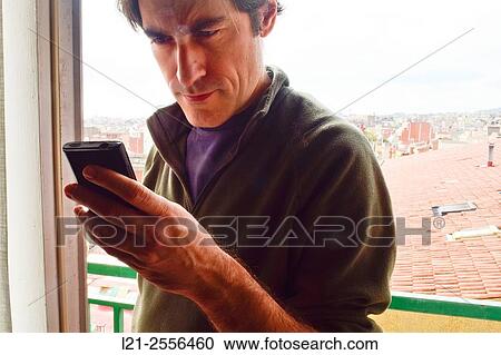 Man with casual clothes using a mobile phone, consulting his smartphone. View Large Photo Image Stock Image - Man with casual clothes using a mobile phone, consulting his smartphone.. Fotosearch