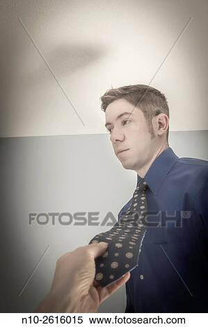 Stock Photography - Mans hand holding young mans tie.. Fotosearch