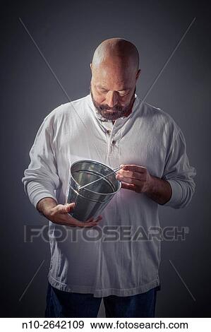 Middle age bald man with a beard, holding a metal bucket. View Large Photo Image Stock Photo - Middle age bald man with a beard, holding a metal bucket.. Fotosearch