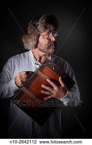 Middle age man, with a beard, glasses, and fur hat, holding a wooden case. View Large Photo Image Stock Image - Middle age man, with a beard, glasses, and fur hat, holding a wooden case.. Fotosearch