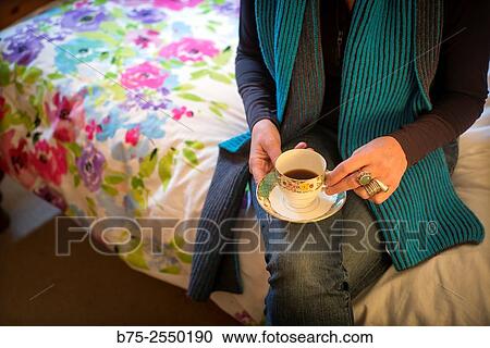 Midle Age Lady, relaxed and calm, seating on the bed side with a cup of coffee in hand. View Large Photo Image Stock Image - Midle Age Lady, relaxed and calm, seating on the bed side with a cup of coffee in hand.. Fotosearch