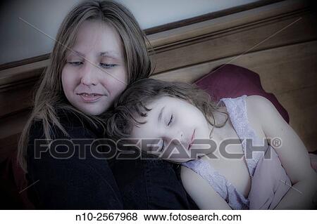 Stock Photo - Mother and six year old daughter on her bed.. Fotosearch