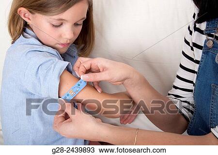 Mother putting a clean dressing on the arm of her daughter View Large Photo Image Stock Image - Mother putting a clean dressing on the arm of her daughter. Fotosearch