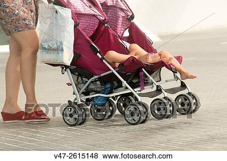 Stock Photo - Mumy dragging a cart of babies with twin bebys, Valencia, Spain, Europe. Fotosearch