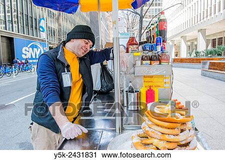 New York, USA. Arabic immigrant to the United States selling Hot Dogs & Pretsels from his mobile stand, Down Town Manhattan. View Large Photo Image Stock Image - New York, USA. Arabic immigrant to the United States selling Hot Dogs & Pretsels from his mobile stand, Down Town Manhattan.. Fotosearch