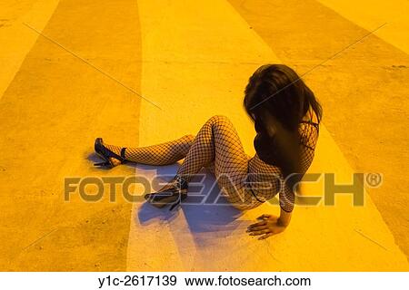 Stock Photo - Night posing young woman in fishnet body-stocking. Fotosearch