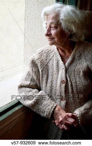 Old woman looking through the window View Large Photo Image Stock Photo - Old woman looking through the window. Fotosearch
