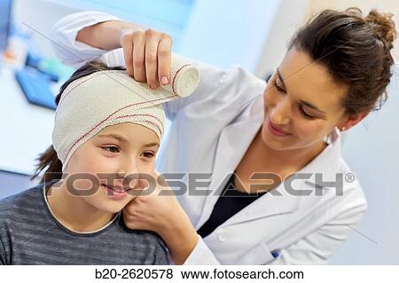 Stock Photo - Otoplasty. winged ears. Malformation there is an absence antehelix crease. Otoplasty involves molding the ear cartilage to create a new fold. Doctor attending to patient medical consultation. Office. Plastic surgery. Pediatrician.. Fotosearch