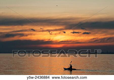 Picture - Person kayaking on Port Phillip Bay at sunset, Melbourne.. Fotosearch