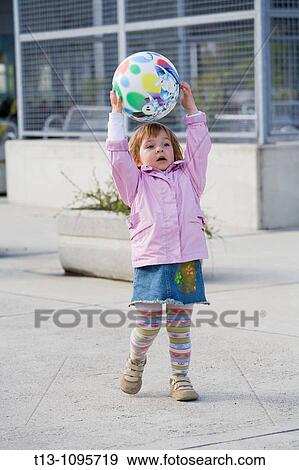 Stock Photo - Playful female toddler with a ball. Fotosearch