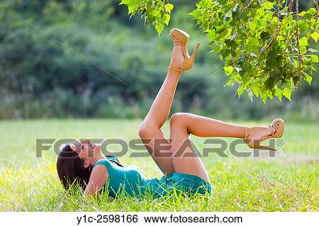 Playful young woman in nature reaching tree-branches View Large Photo Image Stock Photograph - Playful young woman in nature reaching tree-branches. Fotosearch
