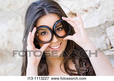 Stock Photo - Playing with bracelet rings as sunglasses. Fotosearch