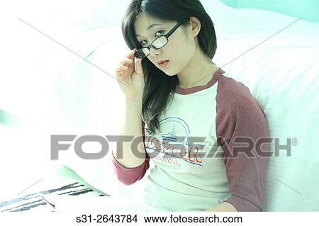 portrait of a beautiful young asian girl from canada reading a book sitting on the floor. View Large Photo Image Picture - portrait of a beautiful young asian girl from canada reading a book sitting on the floor.. Fotosearch