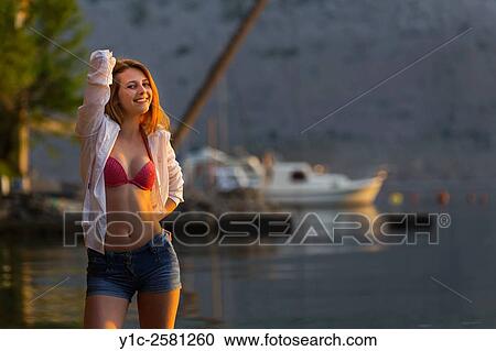 Stock Image - Pretty teen girl posing sidelighted by sunset warm light. Fotosearch