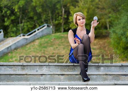 Pretty woman fixing-up looking at handy-mirror View Large Photo Image Stock Image - Pretty woman fixing-up looking at handy-mirror. Fotosearch