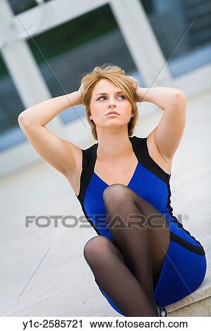 Stock Image - Pretty woman holding head day-dreaming looking up. Fotosearch