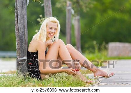 Pretty young woman in park tying laces on high-heels View Large Photo Image Stock Image - Pretty young woman in park tying laces on high-heels. Fotosearch