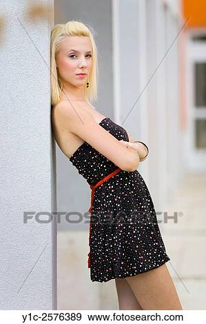 Stock Photo - Pretty young woman is looking at camera side-view. Fotosearch