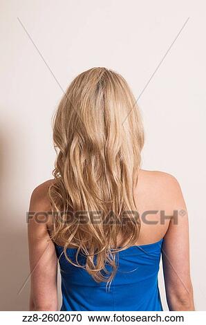 Rear view of a young blonde woman wearing a blue dress. View Large Photo Image Stock Image - Rear view of a young blonde woman wearing a blue dress.. Fotosearch