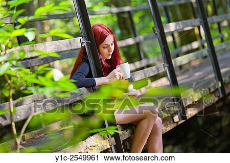 Stock Image - Red-haired young woman drinking tea.. Fotosearch