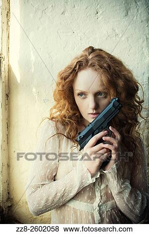 Redhead woman holding a gun. View Large Photo Image Stock Photo - Redhead woman holding a gun.. Fotosearch