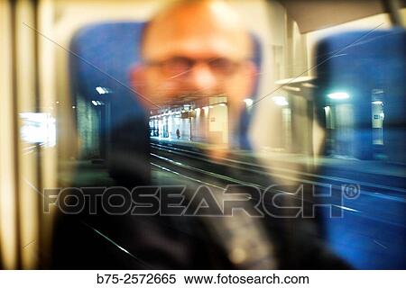 Reflection in the window of a train of a man with glasses and station platform with a person walking in the distance. Italy, Europe View Large Photo Image Stock Photography - Reflection in the window of a train of a man with glasses and station platform with a person walking in the distance. Italy, Europe. Fotosearch