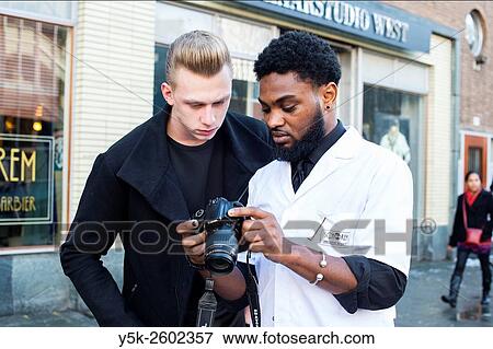 Rotterdam, Netherlands. Barber, working at Schorem Barbers and Haircutters, using a dslar camera to portray his client with new, fresh hairdue. View Large Photo Image Stock Photo - Rotterdam, Netherlands. Barber, working at Schorem Barbers and Haircutters, using a dslar camera to portray his client with new, fresh hairdue.. Fotosearch