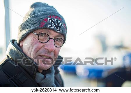 Rotterdam, Netherlands. Middle aged man wearing cap and glasses working outside in cold, winter weather. View Large Photo Image Picture - Rotterdam, Netherlands. Middle aged man wearing cap and glasses working outside in cold, winter weather.. Fotosearch