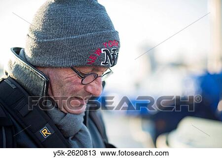 Rotterdam, Netherlands. Middle aged man wearing cap and glasses working outside in cold, winter weather. View Large Photo Image Stock Image - Rotterdam, Netherlands. Middle aged man wearing cap and glasses working outside in cold, winter weather.. Fotosearch
