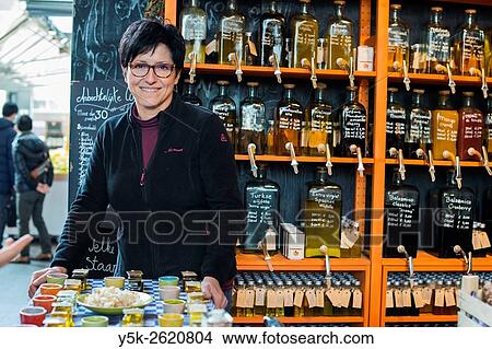 Rotterdam, Netherlands. Middle aged caucasian woman serving customers in a market store selling olive oil and delicatessen. View Large Photo Image Picture - Rotterdam, Netherlands. Middle aged caucasian woman serving customers in a market store selling olive oil and delicatessen.. Fotosearch