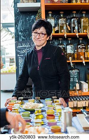 Rotterdam, Netherlands. Middle aged caucasian woman serving customers in a market store selling olive oil and delicatessen. View Large Photo Image Stock Image - Rotterdam, Netherlands. Middle aged caucasian woman serving customers in a market store selling olive oil and delicatessen.. Fotosearch