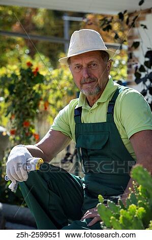 Stock Image - Russian Federation. Belgorod region. The village Solomino. The man in the autumn garden.. Fotosearch