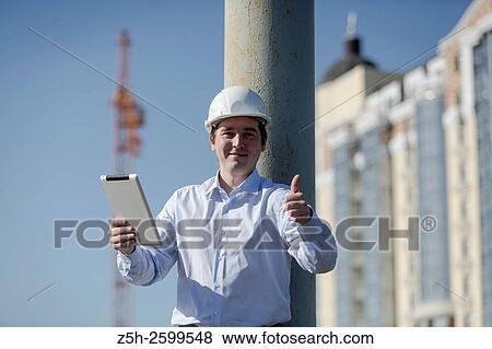 Stock Photo - Russian Federation. Belgorod. Young engineer on a construction site.. Fotosearch