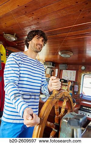Stock Photo - Sailor at the helm of a sailboat, galleon. Basque Country. Spain. Fotosearch