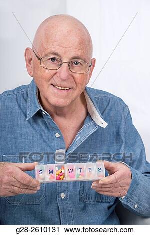 Senior man holding a weekly pill organiser View Large Photo Image Stock Image - Senior man holding a weekly pill organiser. Fotosearch